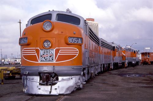An orange train coming around a slight bend